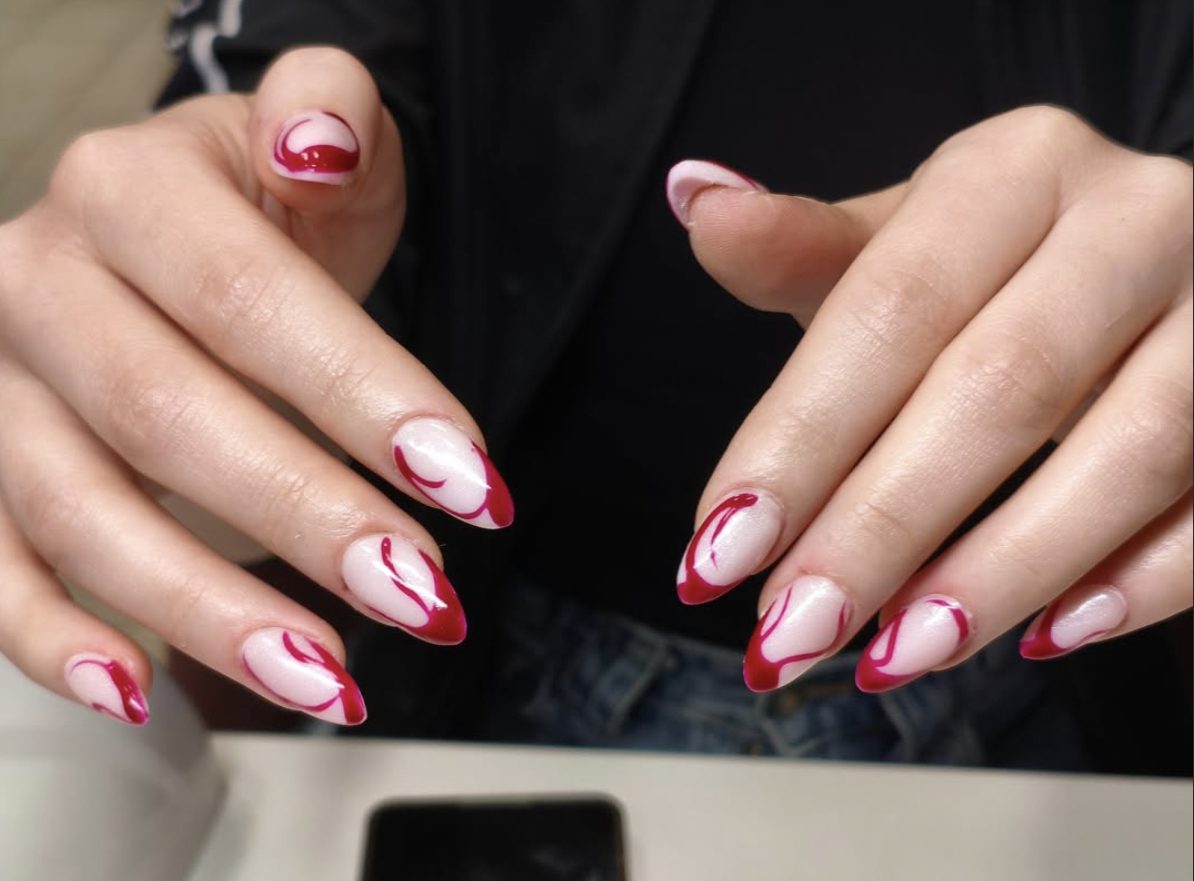 Abstract red French swirl nail art on almond nails