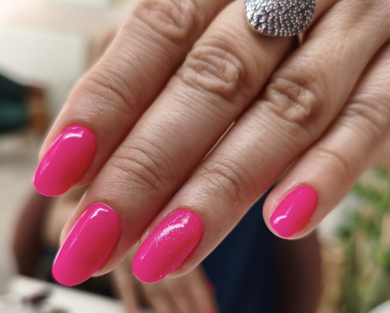 Glossy hot pink fuchsia almond gel manicure with shimmer accent nail